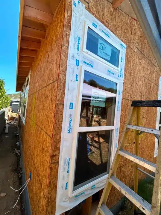 Angled view of exterior cabana wall showing white vinyl windows properly flashed and installed.