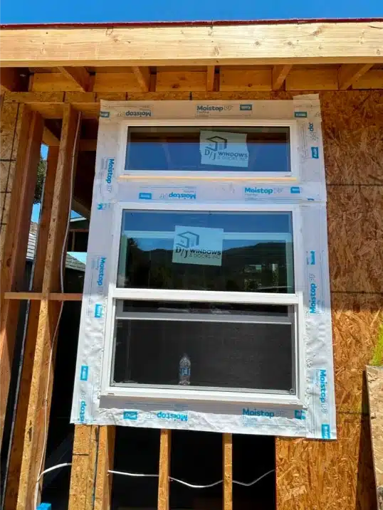 Tall stacked vinyl windows with a ladder indicating active construction progress on the cabana.