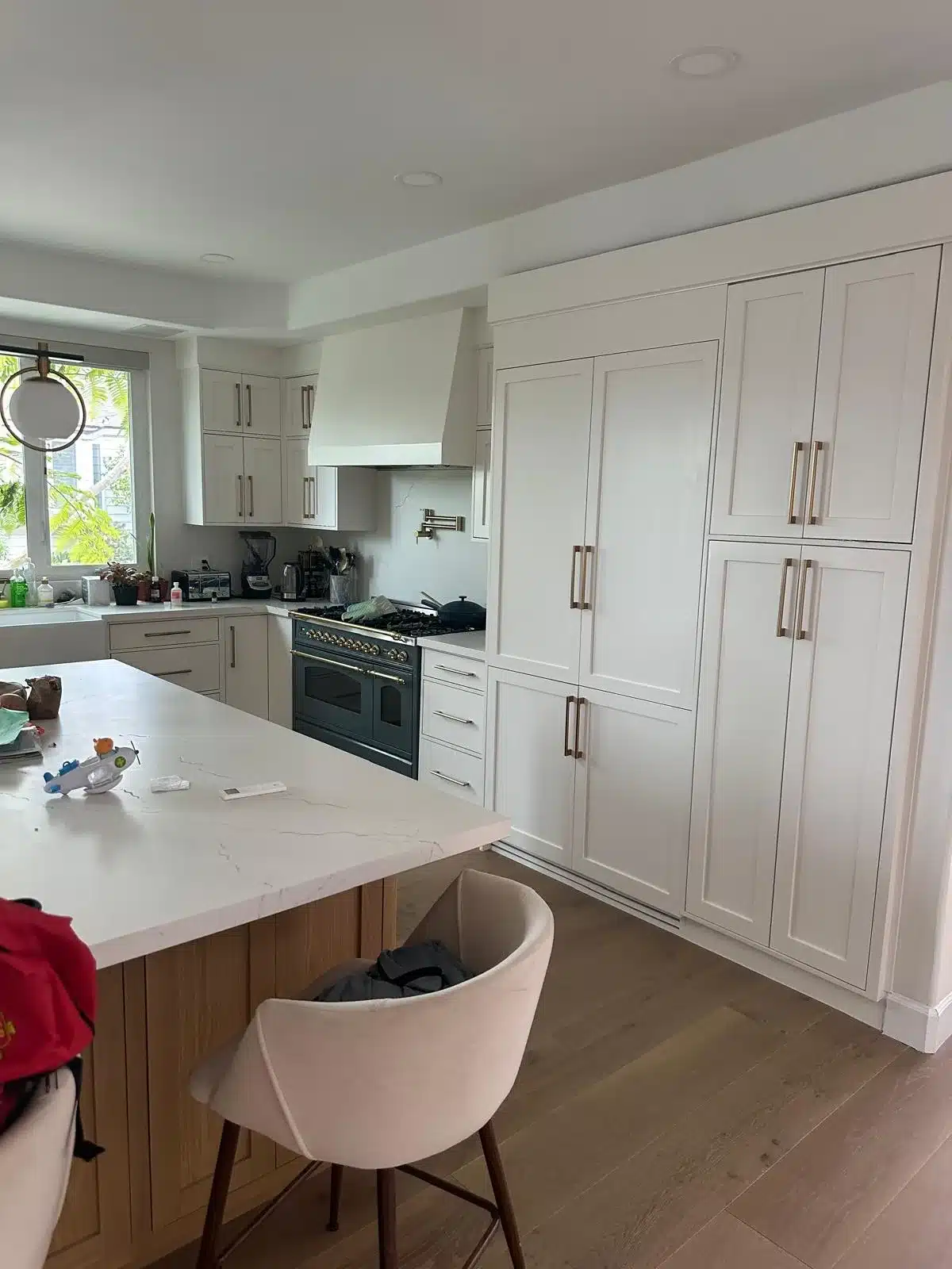 Finished kitchen with light shaker cabinets, a wood-toned island, upholstered seating, and recessed lighting